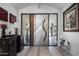 Contemporary foyer boasts unique metal and glass front door, complemented by stylish decor and furnishings at 4801 E Horseshoe Rd, Paradise Valley, AZ 85253