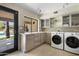 Modern laundry room with custom cabinets, tile floor, and side by side washer and dryer at 4801 E Horseshoe Rd, Paradise Valley, AZ 85253