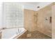 Bathroom featuring a tiled walk-in shower, a garden tub, and a window at 521 N Cambridge St, Gilbert, AZ 85233