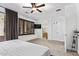 Bright, neutral bedroom with an attached bathroom and an exterior slider with drapes at 521 N Cambridge St, Gilbert, AZ 85233