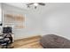 Bedroom featuring a ceiling fan, hardwood floors, and a large window at 521 N Cambridge St, Gilbert, AZ 85233