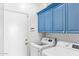 Bright laundry room with front loading appliances, and blue cabinets at 521 N Cambridge St, Gilbert, AZ 85233