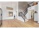 Open-concept living room with wood floors, staircase with iron railings, and bright lighting at 521 N Cambridge St, Gilbert, AZ 85233