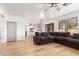 Open-concept living room with wood floors, a large sectional sofa, and views of the kitchen at 521 N Cambridge St, Gilbert, AZ 85233