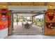 Outdoor patio with dining area, visible through a large, partially open roll-up door at 6310 E Desert Cove Ave, Scottsdale, AZ 85254