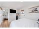 Bright bedroom featuring white walls, wood floors, a TV, and a conveniently located mini fridge and modern, tiled bathroom at 6310 E Desert Cove Ave, Scottsdale, AZ 85254