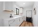 Well-lit laundry room with ample white cabinetry, countertop space, a window, and a convenient rolling laundry sorter at 6310 E Desert Cove Ave, Scottsdale, AZ 85254