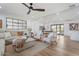 A spacious living room with a comfortable seating arrangement, fan, and views of the dining area at 6310 E Desert Cove Ave, Scottsdale, AZ 85254