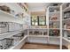 Well-stocked walk-in pantry with custom shelving, storage baskets, and window at 6310 E Desert Cove Ave, Scottsdale, AZ 85254
