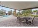 A covered patio area with outdoor dining and beautiful views of the pool and landscaped backyard at 6310 E Desert Cove Ave, Scottsdale, AZ 85254