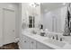 Bright bathroom with double sinks and a large mirror and white cabinets at 6565 E Thomas Rd # 1096, Scottsdale, AZ 85251
