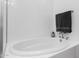Modern bathroom featuring a soaking tub, tiled walls, and sleek fixtures at 6565 E Thomas Rd # 1096, Scottsdale, AZ 85251