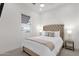 Bright bedroom with a plush upholstered headboard, decorative pillows, and a window with blinds at 6565 E Thomas Rd # 1096, Scottsdale, AZ 85251