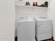 Clean laundry room featuring a washing machine and dryer with storage shelf at 6565 E Thomas Rd # 1096, Scottsdale, AZ 85251