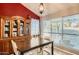 Cozy dining room with a modern table set, a wooden hutch, and a decorative red accent wall at 7222 W Maryland Ave, Glendale, AZ 85303