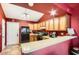 Open kitchen showcasing wooden cabinets, modern appliances, and eat-in bar area at 7222 W Maryland Ave, Glendale, AZ 85303