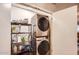 Practical laundry area with a stacked washer and dryer, plus shelving for supplies at 7222 W Maryland Ave, Glendale, AZ 85303