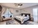 Relaxing main bedroom featuring neutral tones, ceiling fan, sitting area, and natural light at 7222 W Maryland Ave, Glendale, AZ 85303
