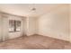 Bedroom with neutral carpet, ceiling fan, and large window at 7833 S Kenneth Pl, Tempe, AZ 85284