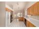 Bright kitchen featuring white tile floor, white countertops and wood cabinets at 7833 S Kenneth Pl, Tempe, AZ 85284