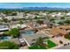Aerial view of a neighborhood with mature trees, manicured lawns, and sparkling swimming pools, all set against a mountain backdrop at 8214 E Northland Dr, Scottsdale, AZ 85251