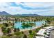 Picturesque aerial view of a lake with surrounding lush greenery, cityscape, and distant mountain range, offering a serene escape at 8214 E Northland Dr, Scottsdale, AZ 85251