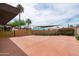 Expansive backyard with a spacious patio, bordered by brick and golden accent walls, and mature landscaping at 8214 E Northland Dr, Scottsdale, AZ 85251