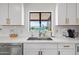Bright kitchen featuring quartz countertops, white cabinets, and stainless steel hardware at 8214 E Northland Dr, Scottsdale, AZ 85251
