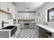 Well-designed laundry room featuring white cabinets, a black farmhouse sink, and designer tile floors at 8214 E Northland Dr, Scottsdale, AZ 85251