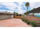 The house features a rear exterior with a brick accent wall, lush greenery and a garage, set on a red concrete driveway at 8214 E Northland Dr, Scottsdale, AZ 85251