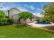 Backyard displaying a lush lawn, mature trees, and a swimming pool with rock waterfall feature at 887 W Santa Gertrudis Trl, San Tan Valley, AZ 85143