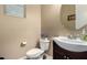 Charming powder room with a vessel sink, dark wood vanity, and a stylish round mirror at 887 W Santa Gertrudis Trl, San Tan Valley, AZ 85143
