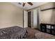 Neutral bedroom featuring carpet floors, overhead ceiling fan, and closet space with an ensuite bath at 887 W Santa Gertrudis Trl, San Tan Valley, AZ 85143