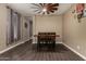 Cozy dining room features a wooden table and chairs under a modern ceiling fan at 887 W Santa Gertrudis Trl, San Tan Valley, AZ 85143