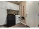 Functional laundry room with modern appliances, ample cabinet space, and durable wood-look flooring at 887 W Santa Gertrudis Trl, San Tan Valley, AZ 85143
