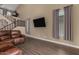 Open-concept living room with hardwood floors, stairs, and comfortable leather seating at 887 W Santa Gertrudis Trl, San Tan Valley, AZ 85143
