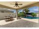 Inviting outdoor living space featuring a covered patio, sparkling pool with a waterfall, and lush landscaping at 887 W Santa Gertrudis Trl, San Tan Valley, AZ 85143