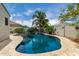 A luxurious backyard pool with a charming rock waterfall, surrounded by mature trees and lush greenery at 887 W Santa Gertrudis Trl, San Tan Valley, AZ 85143