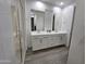 Modern bathroom with double vanity, large mirrors, tiled floor, and a glass-enclosed shower at 9137 W Sells Dr, Phoenix, AZ 85037