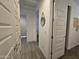 Hallway with doors leading to rooms, stylish mirror decor, and well-maintained flooring and neutral decor at 9137 W Sells Dr, Phoenix, AZ 85037