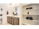 Neutral bathroom featuring double sinks, a large mirror, and organized shelving for convenient storage at 9530 W Avalon Dr, Phoenix, AZ 85037