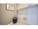 Bright laundry room with white shelving and tan walls at 9530 W Avalon Dr, Phoenix, AZ 85037