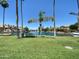 Picturesque community waterfront featuring palm trees, a bench, lush landscaping, and stunning water views at 1020 W Sunward Dr, Gilbert, AZ 85233