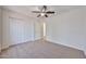 Bright bedroom features neutral carpet, white walls, closet and a ceiling fan at 11626 W Holly St, Avondale, AZ 85392