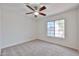 Bright bedroom features neutral carpet, white walls, and a ceiling fan at 11626 W Holly St, Avondale, AZ 85392