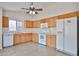 Eat-in kitchen with white appliances, wood cabinets, and large windows overlooking the backyard at 11626 W Holly St, Avondale, AZ 85392