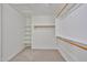 Walk-in closet with wood rods, shelving, and neutral carpet flooring at 11626 W Holly St, Avondale, AZ 85392