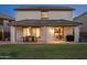 Rear view of the home featuring a covered patio with a dining set and an outdoor grill at 12110 W Rowel Rd, Peoria, AZ 85383