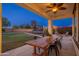 Inviting back patio with a wooden table, chairs, and a view of the backyard, perfect for entertaining at 12110 W Rowel Rd, Peoria, AZ 85383