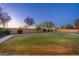 Well-maintained backyard featuring a lush lawn, mature trees, and a paved pathway along the perimeter at 12110 W Rowel Rd, Peoria, AZ 85383